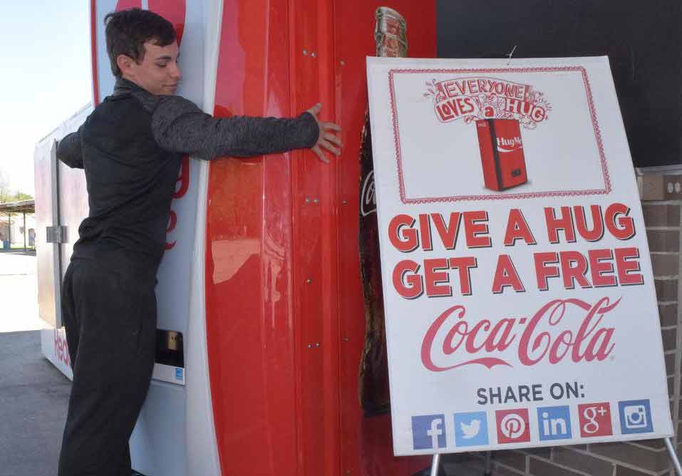 ماشین شادی که توسط کوکا کولا ایجاد شده و با بغل کردن یک نوشابه رایگان می‌دهد - شرکت های موفق با بازاریابی دهان به دهان
